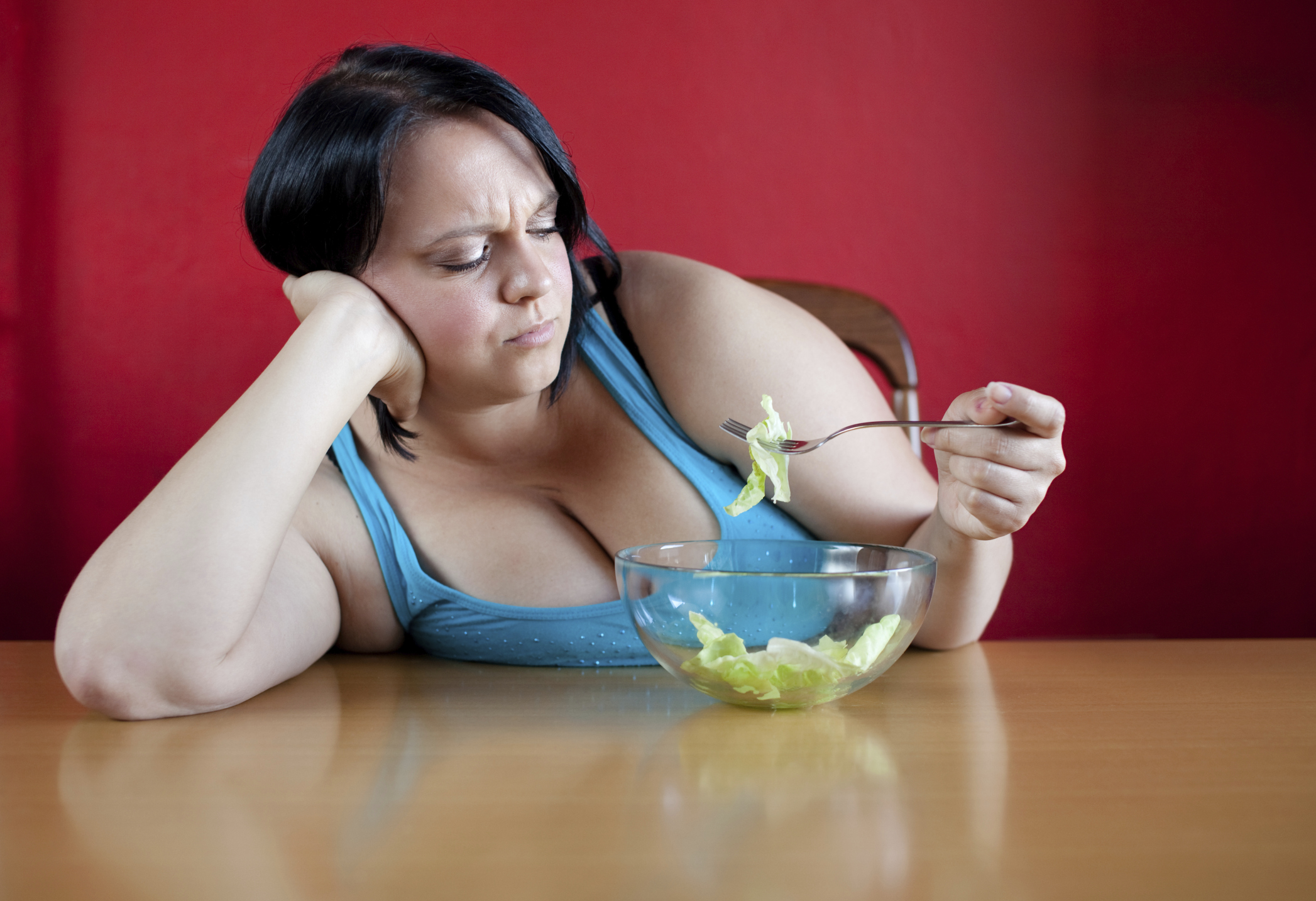 Unhappy overweight woman with her meal